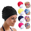 A woman is wearing a black elastic nylon turban swimming cap and various colored versions of the same product.