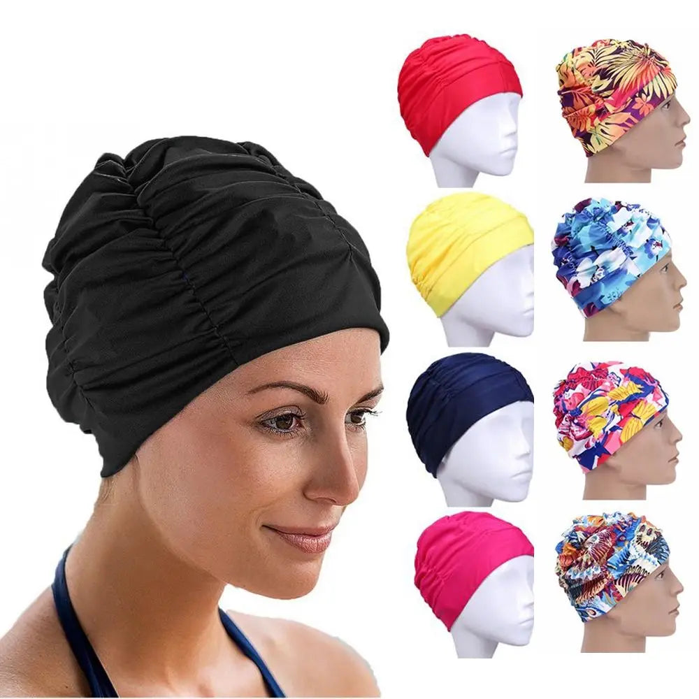A woman is wearing a black elastic nylon turban swimming cap and various colored versions of the same product.