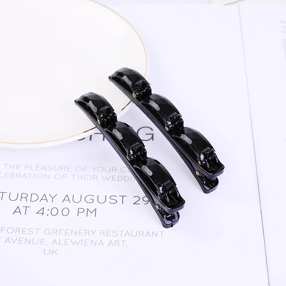 A pair of black double layer headband featuring pearl and rhinestone embellishments.