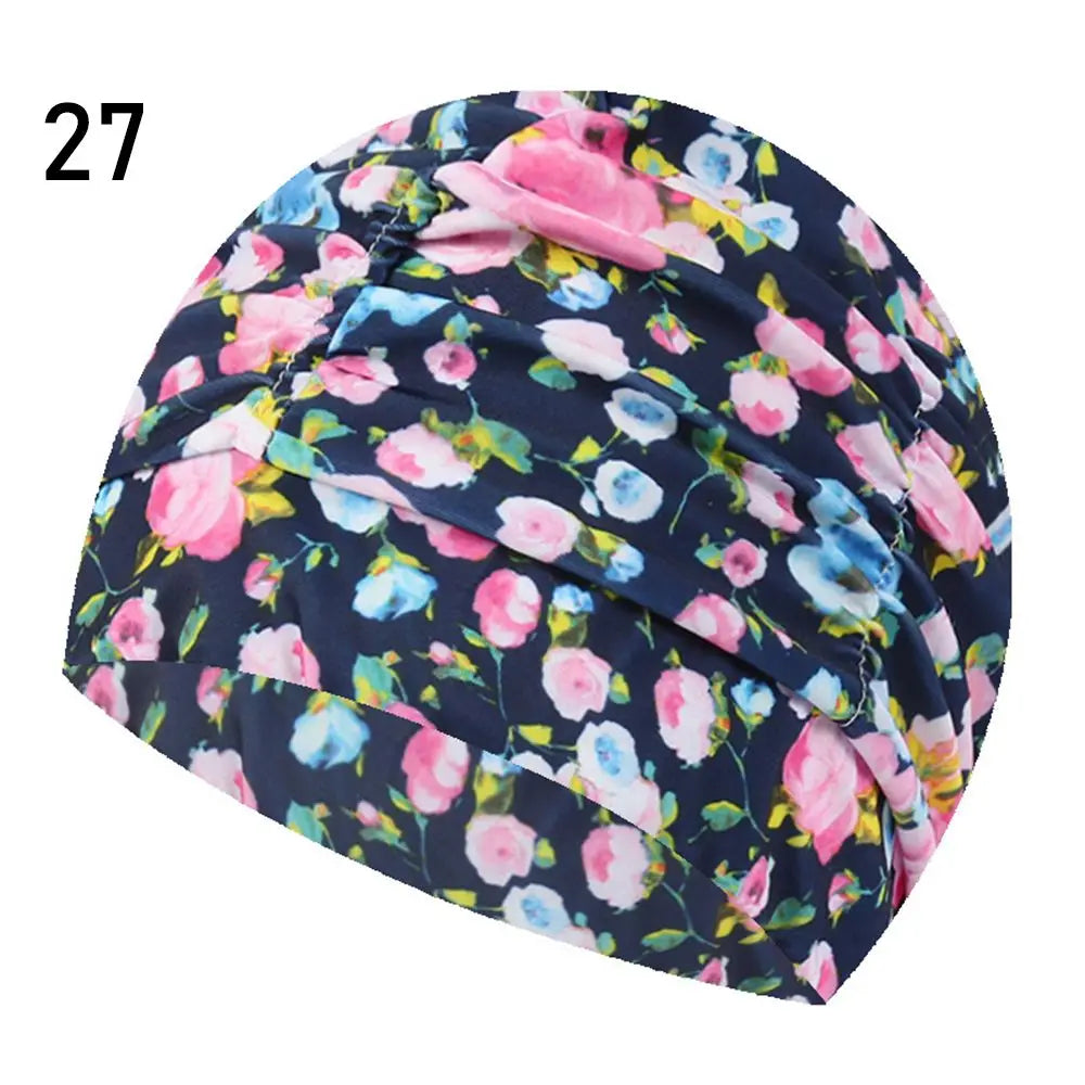 A dark blue and pink floral patterned elastic nylon turban swimming cap.