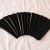 A fan of black elastic headbands arranged in a semi-circle on a white surface.