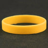 A yellow silicone elastic wristband lying on a dark surface.