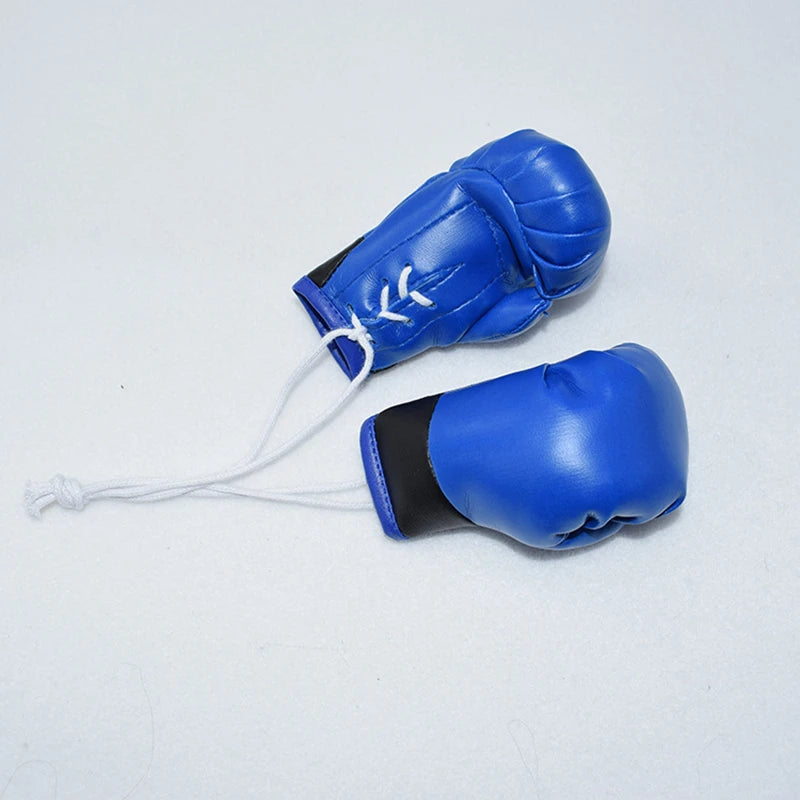 Guante de boxeo de cuero azul con acento negro y cordón blanco como llavero.