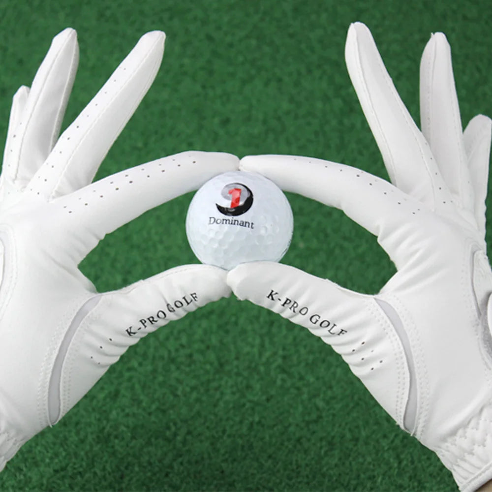 A pair of white golf gloves holding a white golf ball with the number 1 on it against a green background.