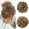 A close-up of messy curly hair bun extensions styled in an updo, showing various textures and shades of brown hair.