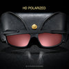 A pair of black polarized sunglasses with gold accents resting on a dark surface.