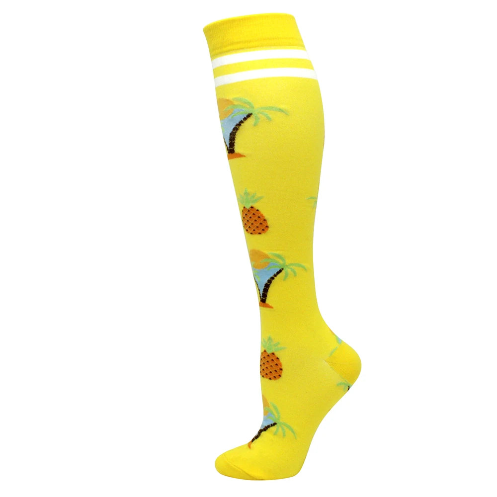 Yellow compression socks with a tropical fruit pattern and white stripes