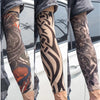 Close-up of a person wearing black and grey reusable UV protection tattoo arm sleeves on their forearm.
