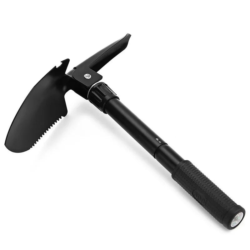 A black foldable multi-tool shovel with a blade and handle is shown against a white background.
