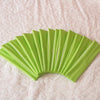 A fan of bright lime green elastic headbands arranged in a curved, overlapping fan shape on a white surface.