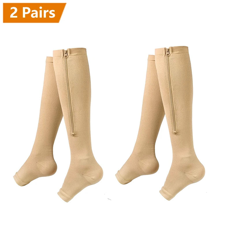 Two pairs of beige compression socks with zippers shown flat