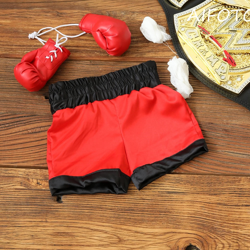 Guante de boxeo rojo y pantalones deportivos con ribete negro exhibidos sobre una superficie de madera.