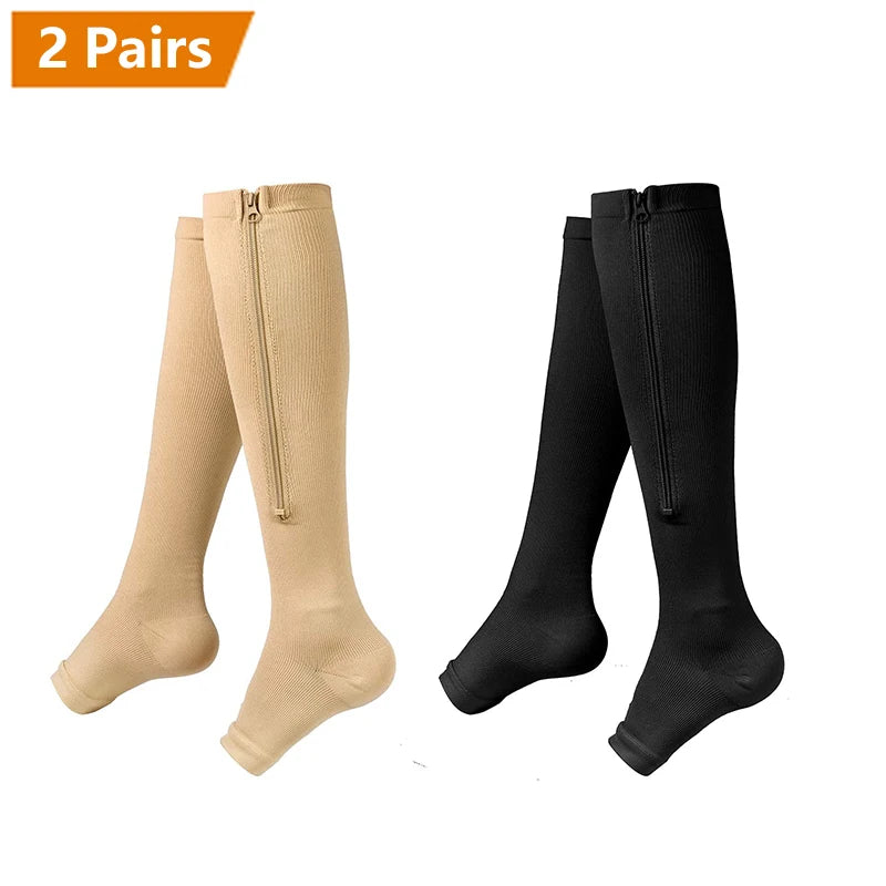 Two pairs of beige and black compression socks with zippers shown flat