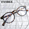 A pair of brown and blue patterned square frame glasses resting on a white wire mesh background.