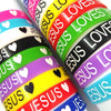 A close-up of colorful silicone religious cuff bracelets stacked diagonally.