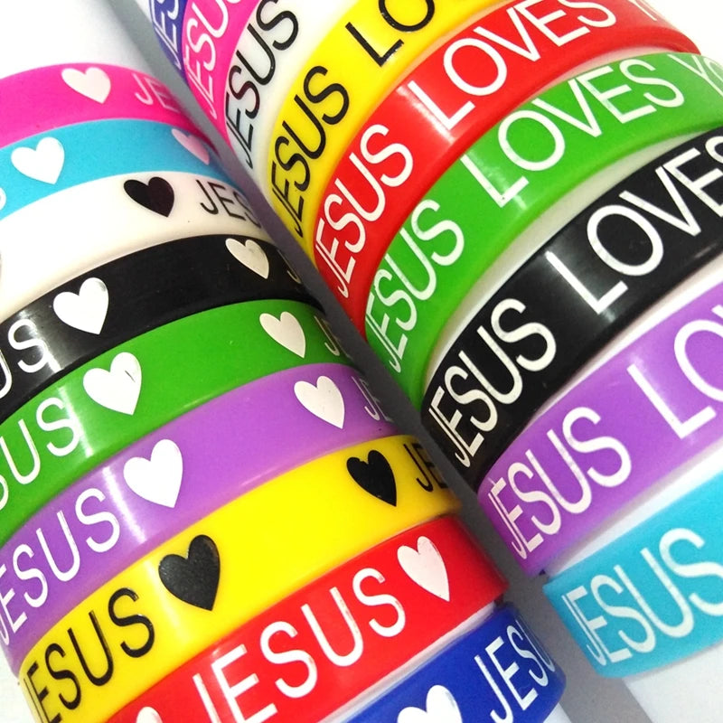 A close-up of colorful silicone religious cuff bracelets stacked diagonally.