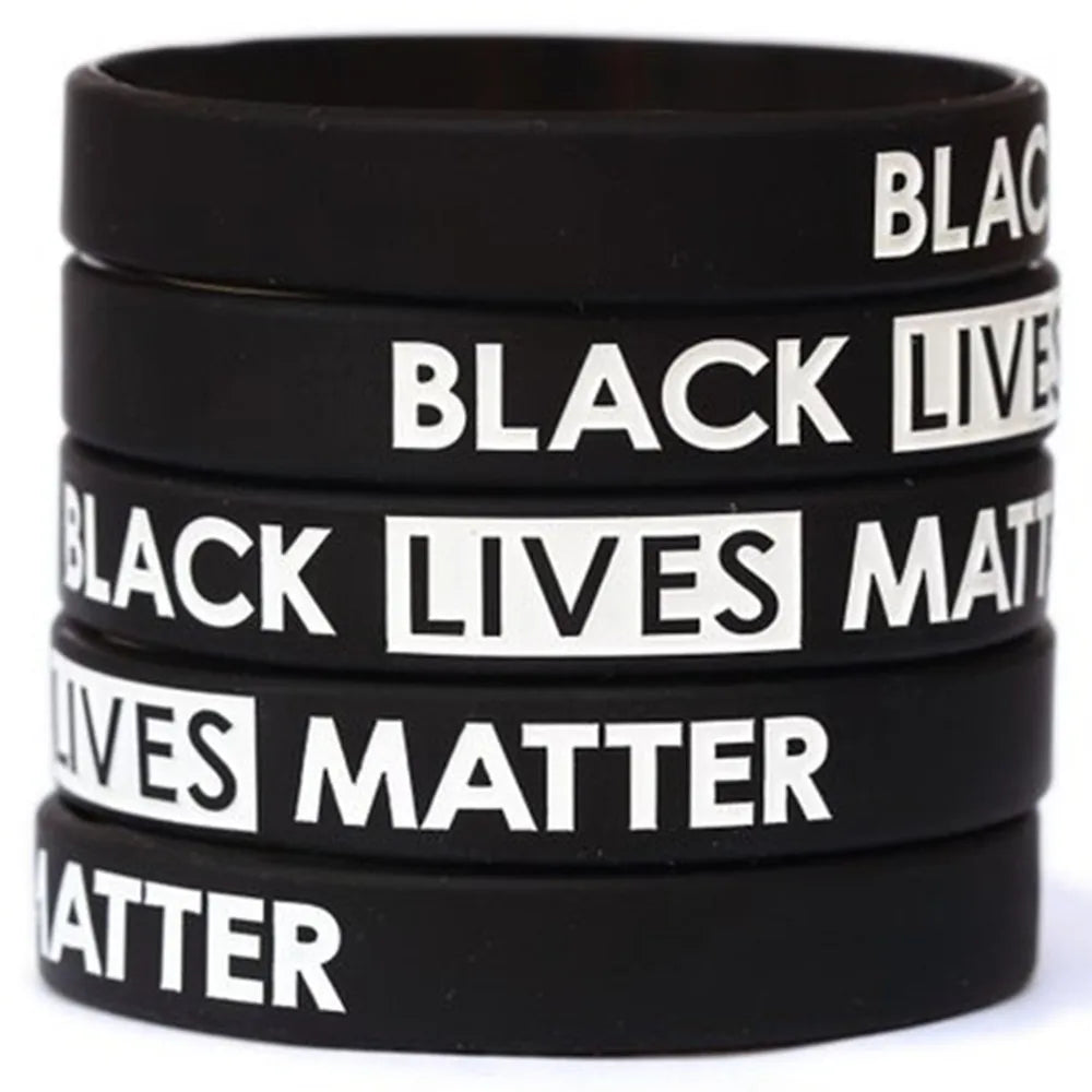 Stack of black silicone wristbands with white text reading Black Lives Matter
