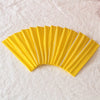 A fan of bright yellow elastic headbands arranged in a semi-circle on a white surface.