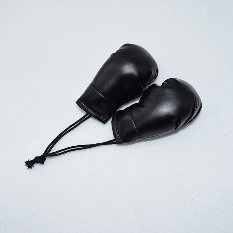 Llavero de guante de boxeo de cuero negro con un cordón negro fino.