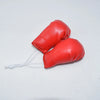 Guante de boxeo de cuero rojo brillante como llavero con una cuerda blanca atada.