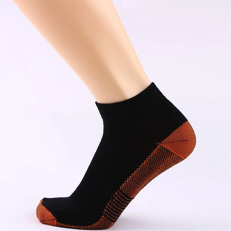Bas de compression noirs avec accents en fibre de cuivre sur le pied d'un mannequin.