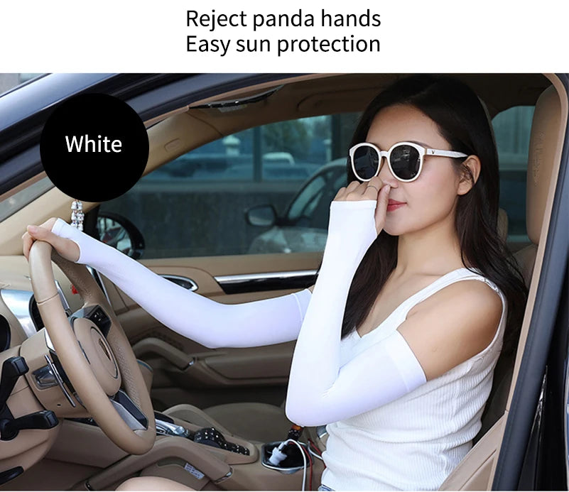 A woman wearing white fingerless arm sleeves is driving a car, demonstrating sun protection.