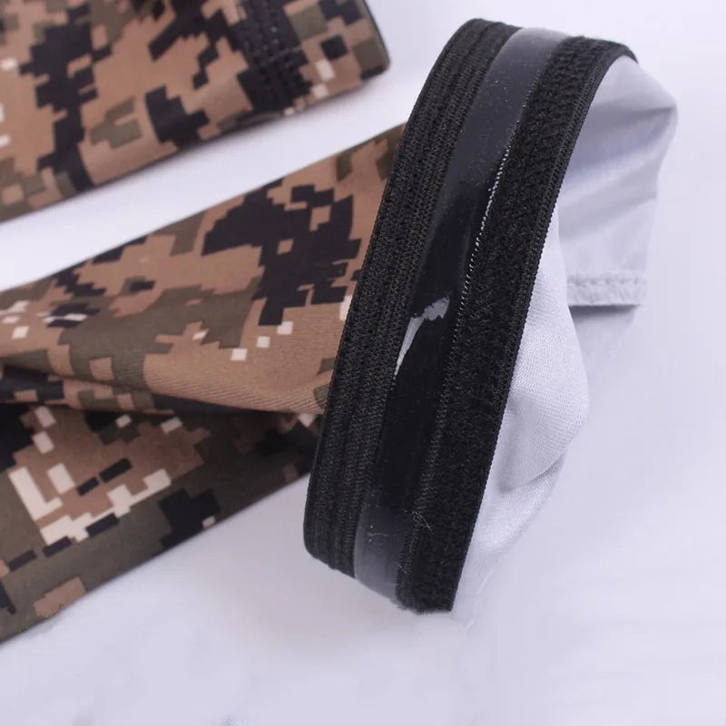 Close-up of black and tan camouflage tactical arm sleeves rolled up