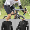 A man wearing black cycling arm sleeves and a helmet is riding a bicycle outdoors.