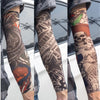 Close-up of a person wearing reusable UV protection tattoo arm sleeves featuring detailed black and gray tribal and skull des