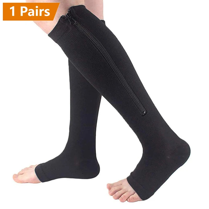 A pair of black zipper compression socks being worn on a foot.