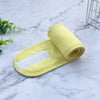 A rolled yellow absorbent cloth with a white strip is placed on a marble surface.