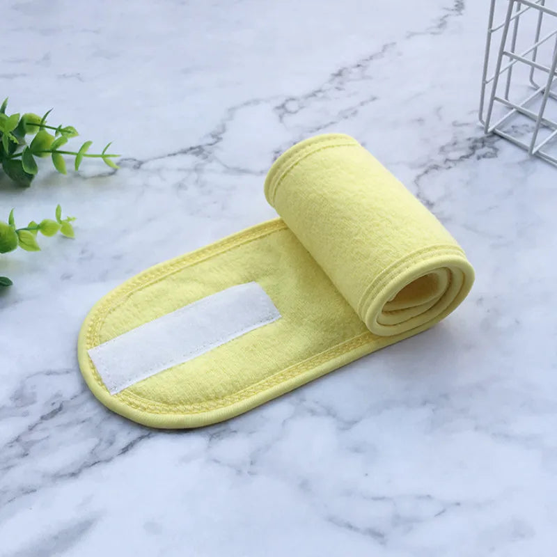 A rolled yellow absorbent cloth with a white strip is placed on a marble surface.