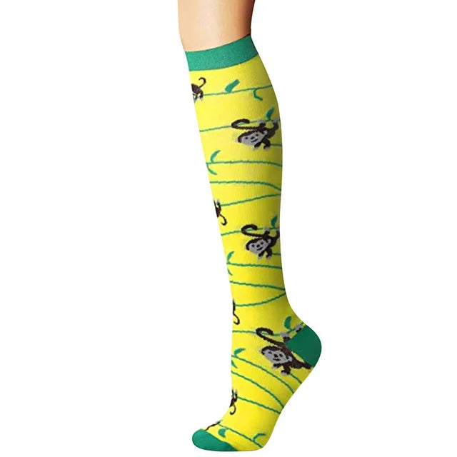 Yellow compression socks with green trim featuring black animal print designs.