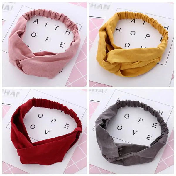Three twisted knotted elastic headbands in pink, yellow, and red fabric displayed against a light background.