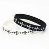 Black silicone cross wristband with white decorative stitching on a white background.