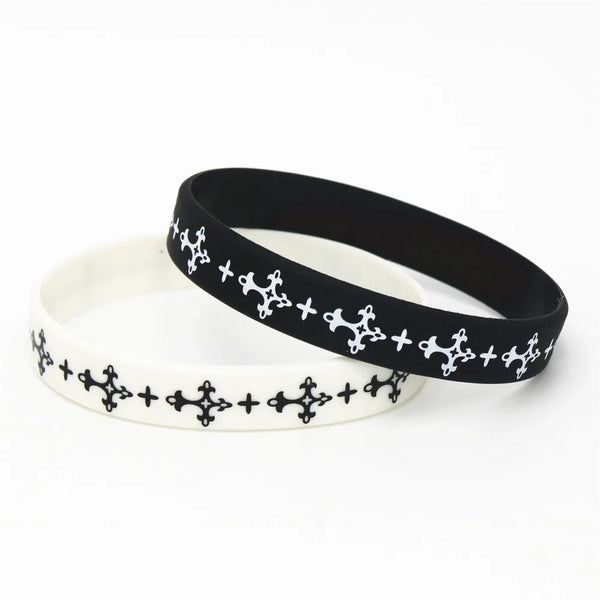 Pulsera de silicona negra con cruz y costura decorativa blanca sobre fondo blanco.
