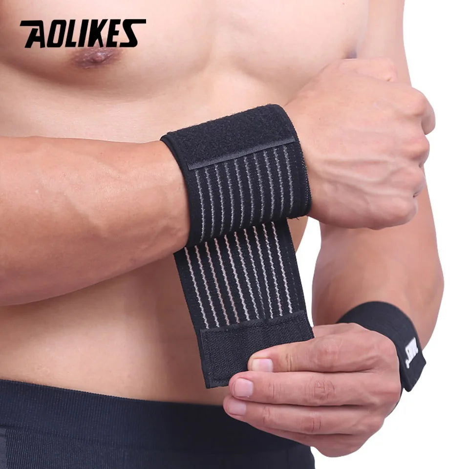 Black elastic wrist straps being worn on a person's forearm for support.