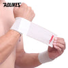 A hand is wearing a white elastic wrist strap for sports and daily support.