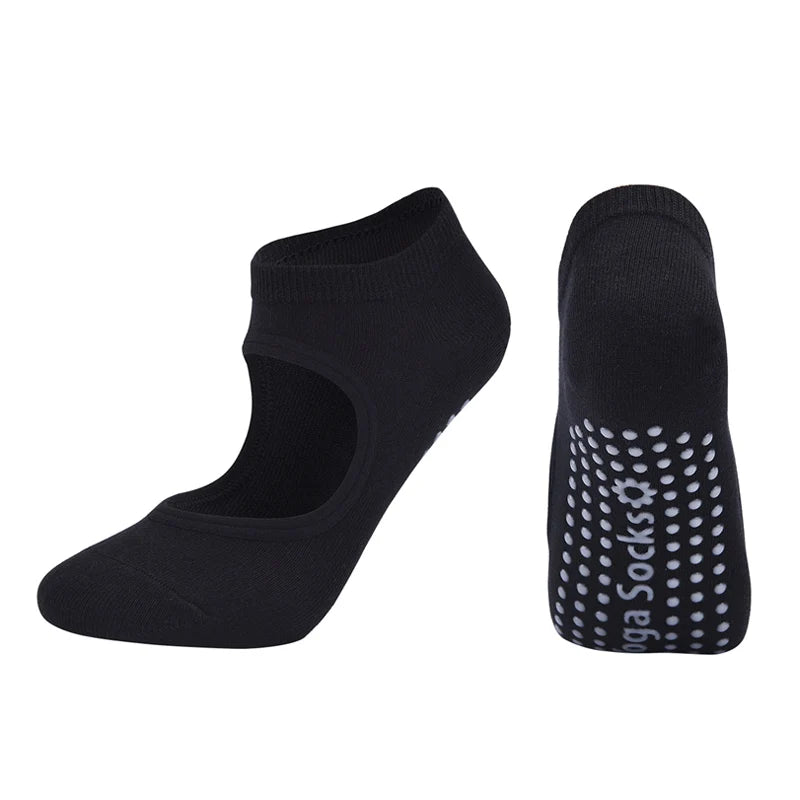 A pair of black breathable women's pilates and yoga socks, one solid and one with white dots.