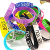 A collection of colorful silicone cuff bracelets with various text designs including Jesus loves you and Jesus loves.