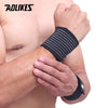 A person is wearing a black elastic wrist strap on their forearm for support or sports.