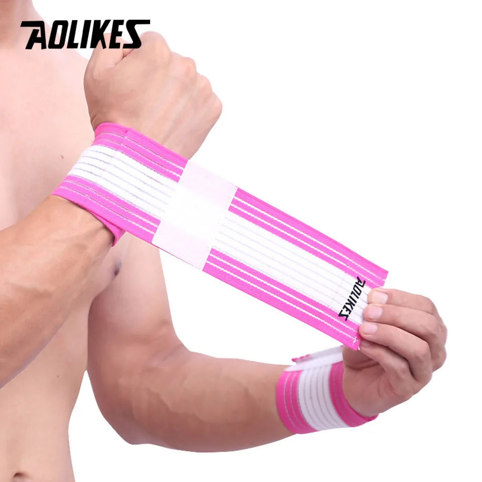 A hand is holding a pink and white striped elastic wrist strap for sports and daily support.