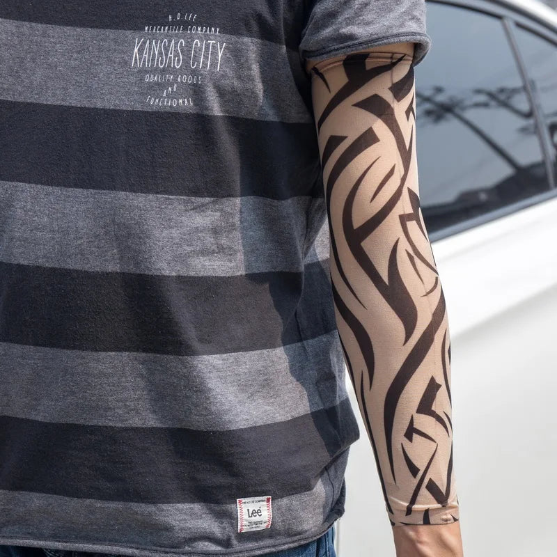 A person wearing a gray striped shirt and black tattoo arm sleeves.