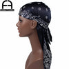 Model wearing a black silk paisley durag headscarf with white embroidery