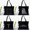 Black canvas tote bags featuring various faith-based messages and Jesus text prints.