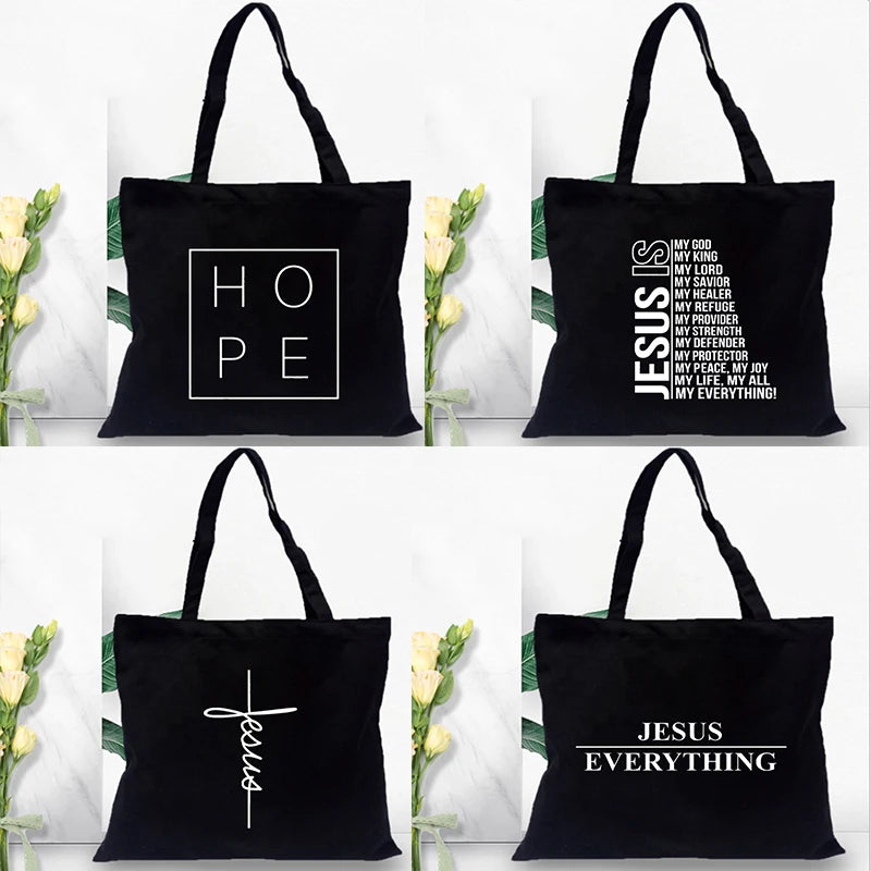 Black canvas tote bags featuring various faith-based messages and Jesus text prints.