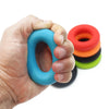Une main tient un anneau de préhension en silicone bleu, avec une pile d'anneaux colorés en arrière-plan.