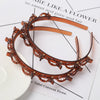 A double layer headband made of amber-colored material adorned with small pearls and rhinestones.