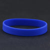 A bright blue silicone elastic wristband lying flat on a dark surface.