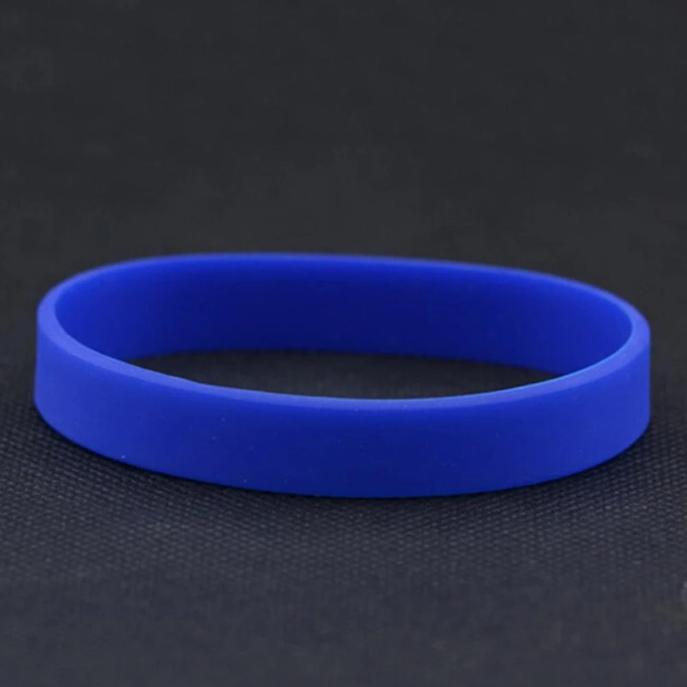 A bright blue silicone elastic wristband lying flat on a dark surface.